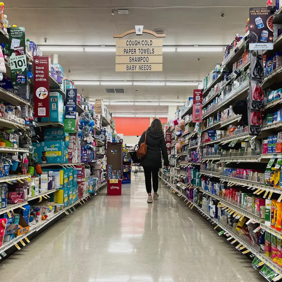 Customer walking through a retail store aisle with baby and health products