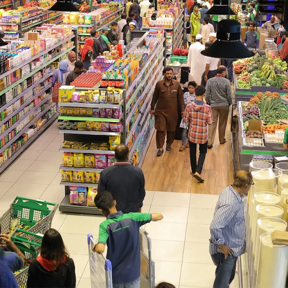 Busy supermarket in Windham County, CT with shoppers buying groceries, produce, and essentials using modern POS systems.