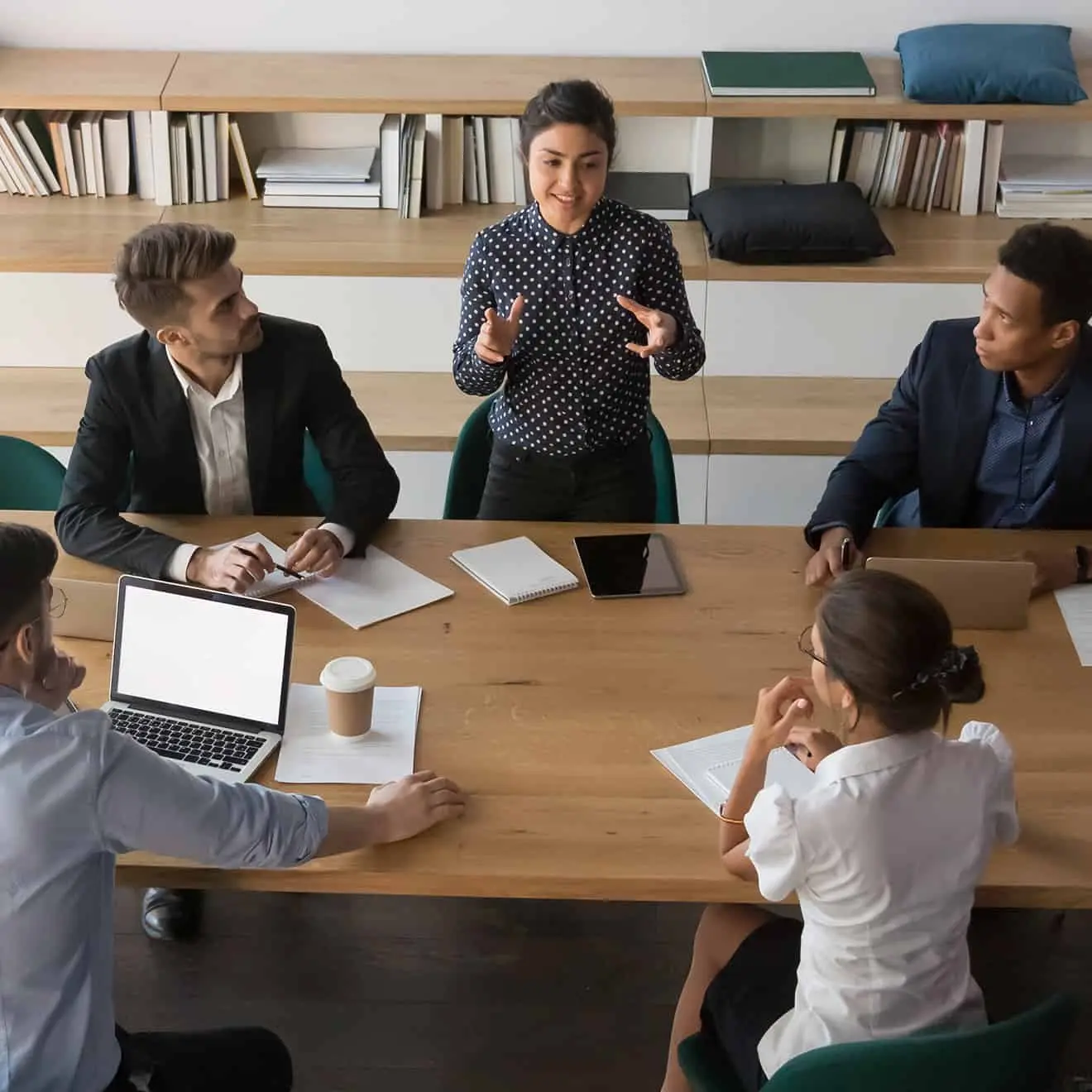 Business team in a modern office having a meeting while a woman presents ideas confidently during a professional discussion